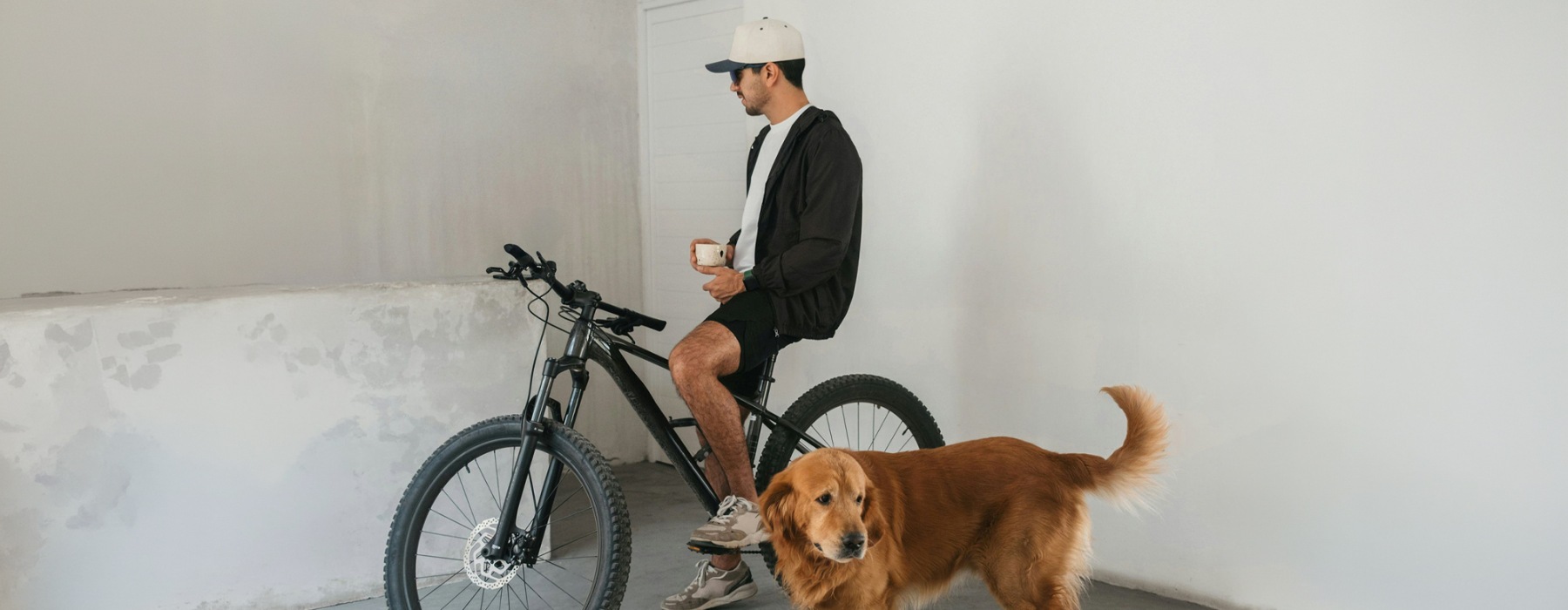a man beside a dog and his bicycle